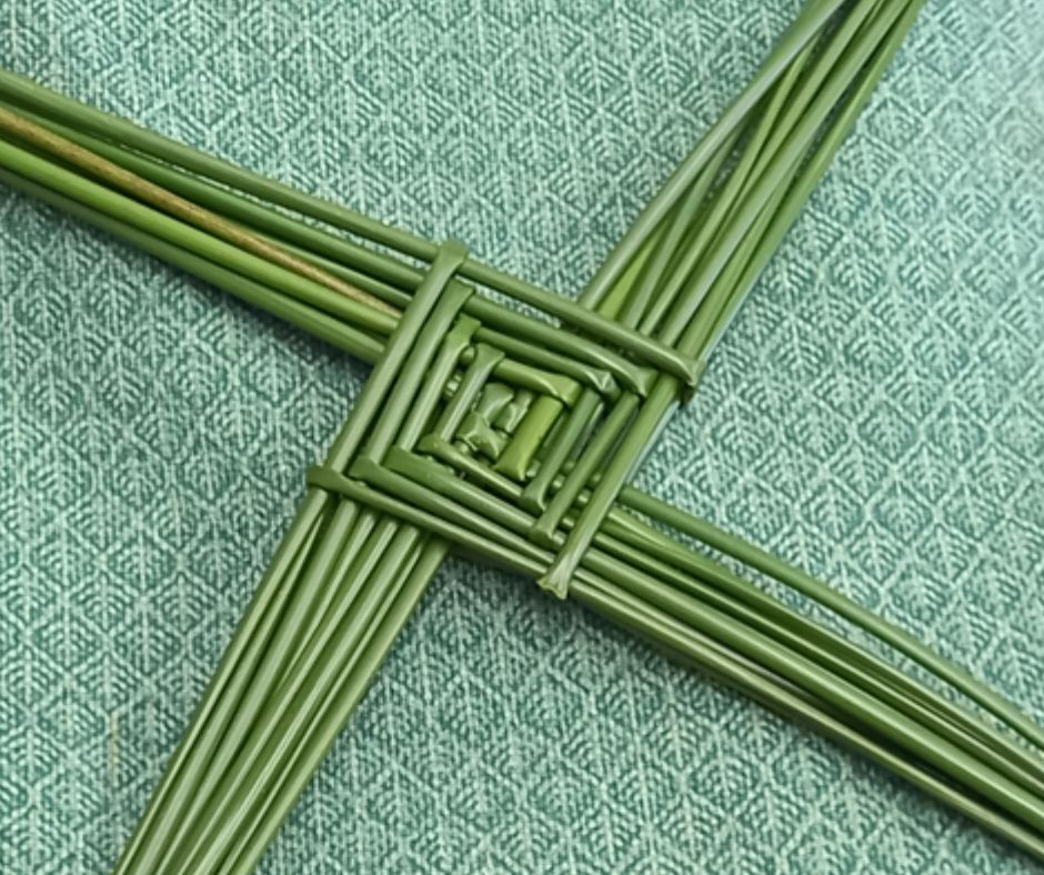 A St Brigid's Cross laid on a green cloth.