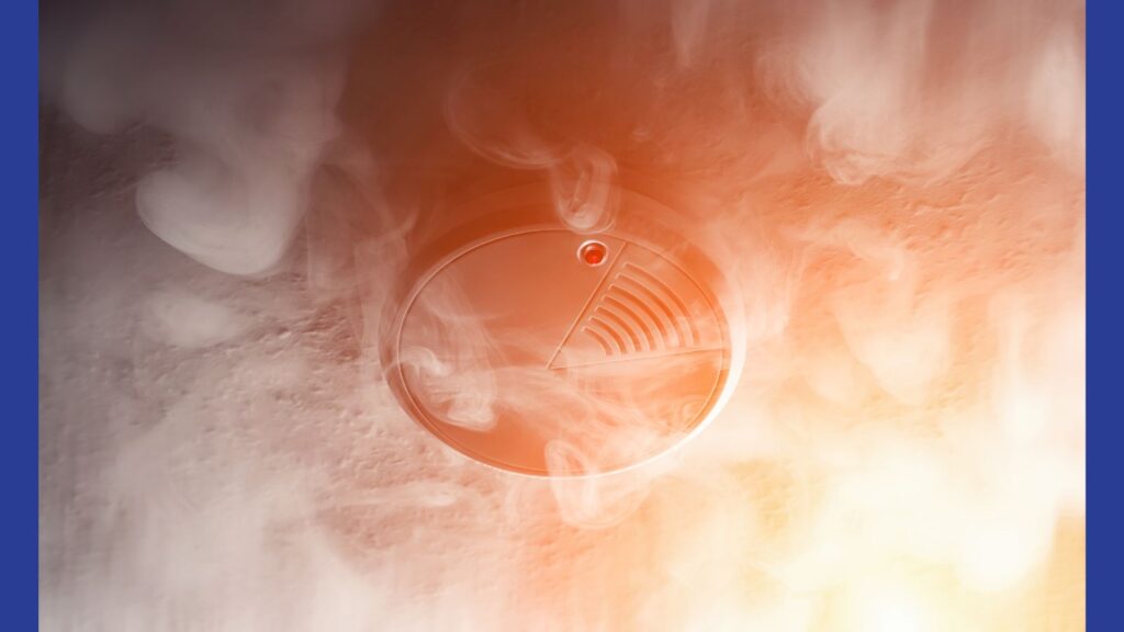A photograph of smoke reaching a fire alarm on a roof .