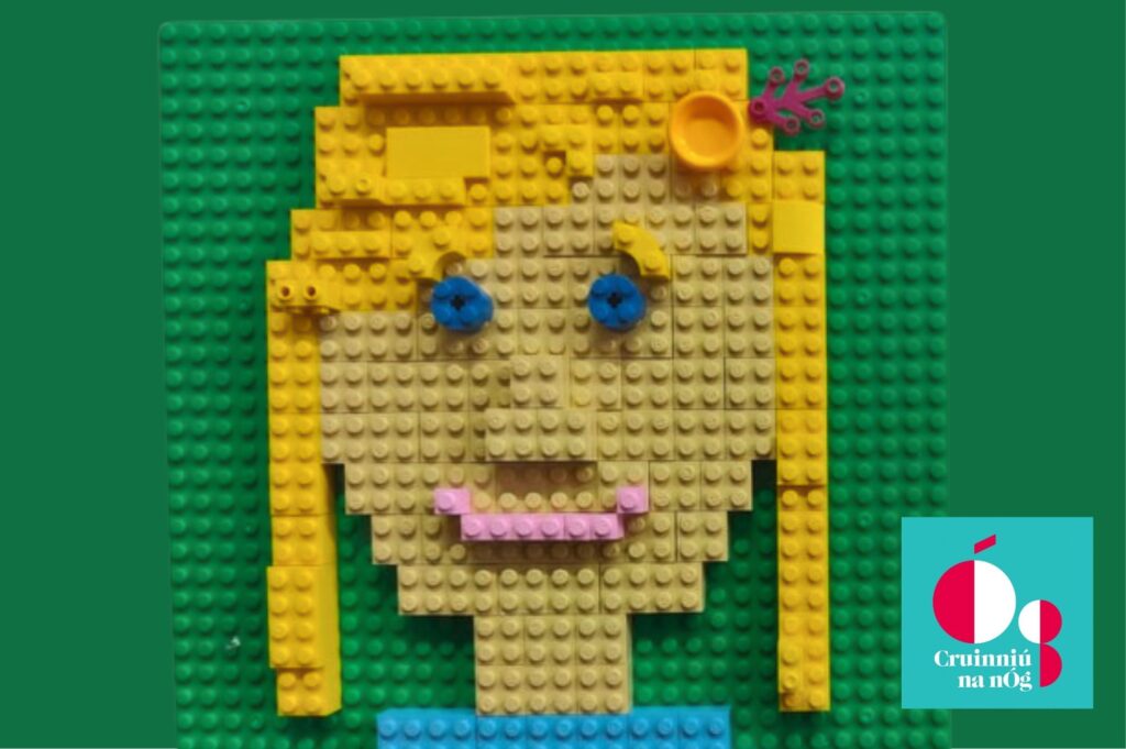 A portrait of a girl with blond hair and blue eyes on a green background created using Lego bricks.