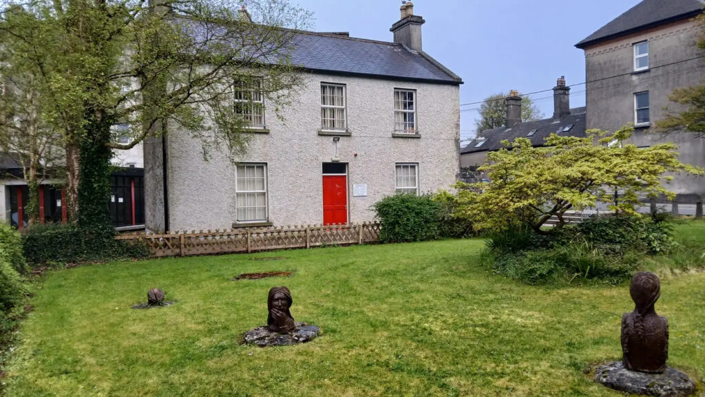 Exterior of Clare Local Studies Centre, an old detached building with a red door