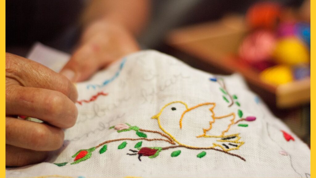 A handkerchief being embroidered by hand.